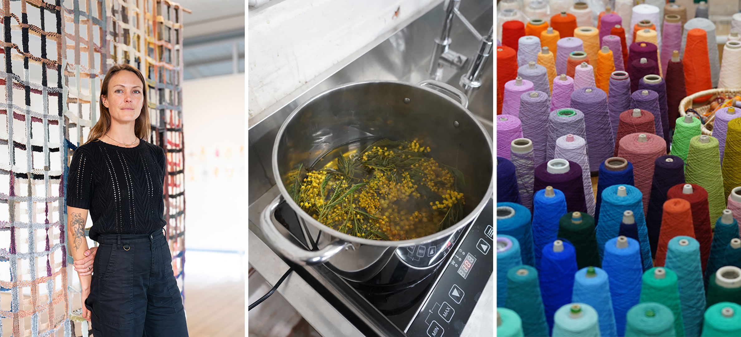 A woman stands in a gallery space amongst her brightly coloured artworks, brightly coloured yarn and a kitchen pot filled with yellow wattle flowers